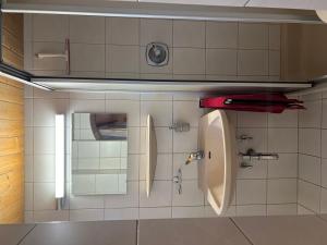 a bathroom with a urinal and a sink at Berghaus Biberwier in Biberwier