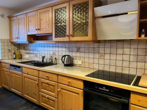 a kitchen with wooden cabinets and a counter top at Berghaus Biberwier in Biberwier