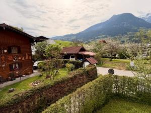 a house with a fence and mountains in the background at FeWo Altes Doktorhaus in Berchtesgaden