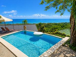 a swimming pool with a view of the ocean at Vista Naranja Retreat in Santa Teresa Beach