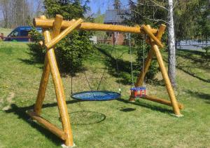 a wooden cross with a swing on the grass at Chalet Martuška - Drevenica so saunou - Celá dolina len pre vás in Levoča