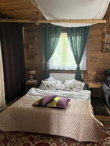 a bedroom with a large bed with blue curtains at Ślimakowa chatka jak u babci in Parczew