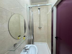a bathroom with a sink and a shower with a mirror at Lyon House Hotel in Barking +29 photos