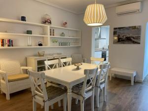 a kitchen and dining room with a table and chairs at Apartamentos Torre Playa in Port de Pollensa