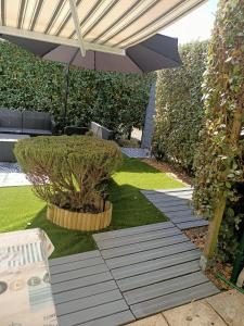 a patio with an umbrella and plants in a yard at Joli Appartement Audenge in Audenge +9 photos