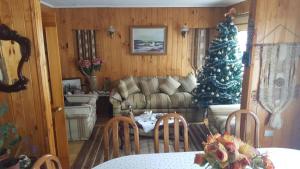 una sala de estar con un árbol de Navidad y un sofá en Hostal Costa Azul en Castro