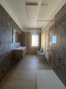 a bathroom with two sinks and a toilet and a window at Velù Apartment in Porto Viro +46 photos