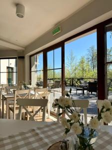 a dining room with a table and chairs and windows at Villa Sobótka in Sobótka