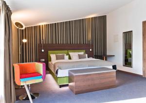 a hotel room with a bed and a chair at Steinberger Hof in Dietzenbach +94 photos