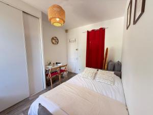 a bedroom with a bed and a red curtain at Studio cosy parking in Margny-lès-Compiègne +4 photos