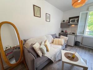 a living room with a couch and a mirror at Studio cosy parking in Margny-lès-Compiègne