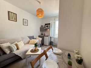 a living room with a couch and a table at Studio cosy parking in Margny-lès-Compiègne