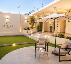 an outdoor patio with chairs and an umbrella at Altitud 620 Boutique Suites in Nazca