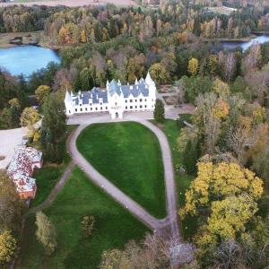 an aerial view of a large white house on a green field at Alatskivi Castle in Alatskivi