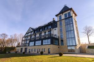 a large brick building with a black roof at Kryla by Shepilska in Dolgoluka