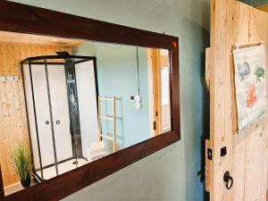 a mirror with a wooden frame on a wall at The Forgotten Farmhouse in Skogar +45 photos