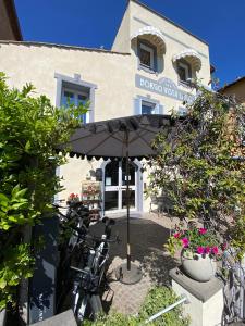 a patio with an umbrella in front of a building at Hotel Borgo Vista Lago in Trevignano Romano