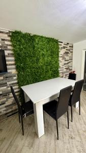 a white table and chairs in a room with a green wall at Casa Ducaru Moieciu de Sus in Moieciu de Sus