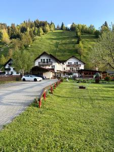 a car parked in front of a house with a hill at Casa Ducaru Moieciu de Sus in Moieciu de Sus