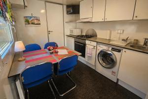 a small kitchen with a table and blue chairs at Weinschlafwagen Bautzen in Bautzen