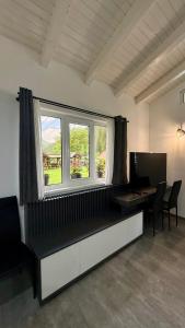 a room with a desk with a computer and a window at Casa Ducaru Moieciu de Sus in Moieciu de Sus