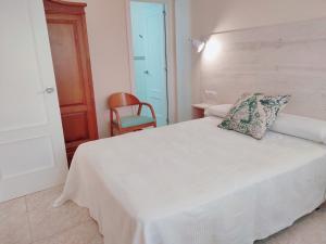 a bedroom with a white bed with a pillow on it at Hotel Rodeiramar in Cangas de Morrazo