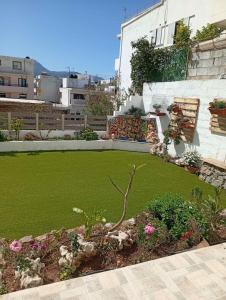 a garden with green grass and a building at Georgia's garden 2 in Sitia
