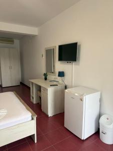 a room with a desk and a tv on the wall at Angely Summer Vila in Eforie Nord
