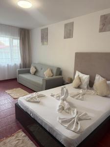 a bedroom with a large bed with towels on it at Angely Summer Vila in Eforie Nord