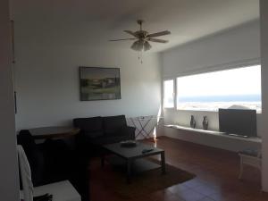 a living room with a couch and a ceiling fan at Finca La Calera Lanzarote - Calma in Güime
