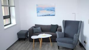 a living room with a couch and a table and a chair at Appelholt in Wremen