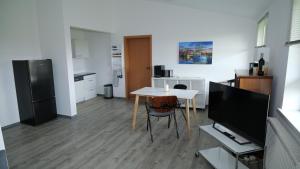 a kitchen with a table and a tv in a room at Appelholt in Wremen