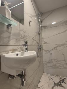 a white bathroom with a sink and a shower at My Guest Rooms in Plovdiv +57 photos