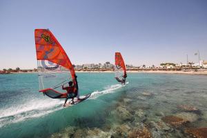 two people are windsurfing in the water on the beach at Safaga SeaView Rooftop in Safaga