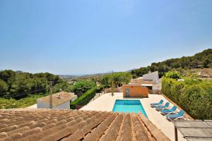 a villa with a swimming pool and blue lounge chairs at Marques - holiday home with private swimming pool in Benitachell in Benitachell