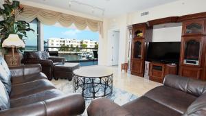 a living room with leather furniture and a flat screen tv at 124 Mariners Club in Key Largo