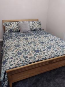 a bed with a blue and white bedspread and pillows at DRIFTWOOD coastal holiday flat - newly refurbished with 2 bedrooms in Largs