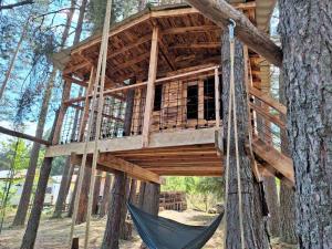 a tree house with a hammock in the middle at Вила Bora Vista 2 in Tsigov Chark