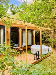 a wooden deck with a bath tub in a gazebo at Bambou Lodge & Spa in Arles +11 photos