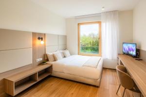 a hotel room with a bed and a window at Cessange House by Rentaroo in Luxembourg