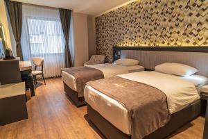 a hotel room with two beds and a desk at Selçuk Hotel in Konya +169 photos