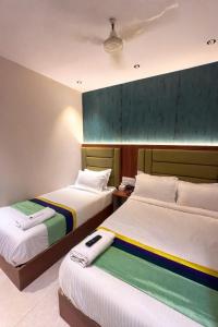two beds in a hotel room with two bedsskirts at Ruby Hotel in Mumbai +33 photos