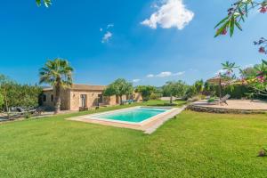 a yard with a swimming pool and a house at Sa Punta in Son Carrió