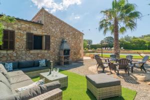 a patio with a couch and chairs and a table at Sa Punta in Son Carrió