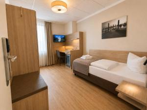 a hotel room with a bed and a desk at Hotel Wania in Hamburg