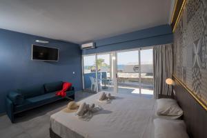 a bedroom with a bed and a couch and a view at Stalis Hotel in Stalís +38 photos