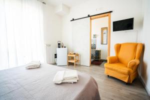 a bedroom with a bed and a yellow chair at Casa Immacolata in Polignano a Mare