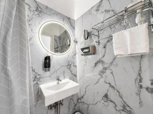 a white bathroom with a sink and a mirror at Hotel Wania in Hamburg +33 photos