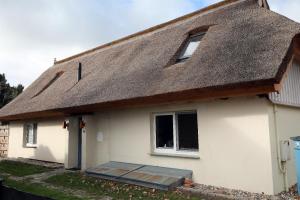 a thatch roofed house with a thatched roof at Haus Wünsche in Wieck