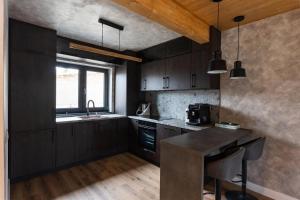 a kitchen with black cabinets and a counter top at Sadova Chalet in Sadova
